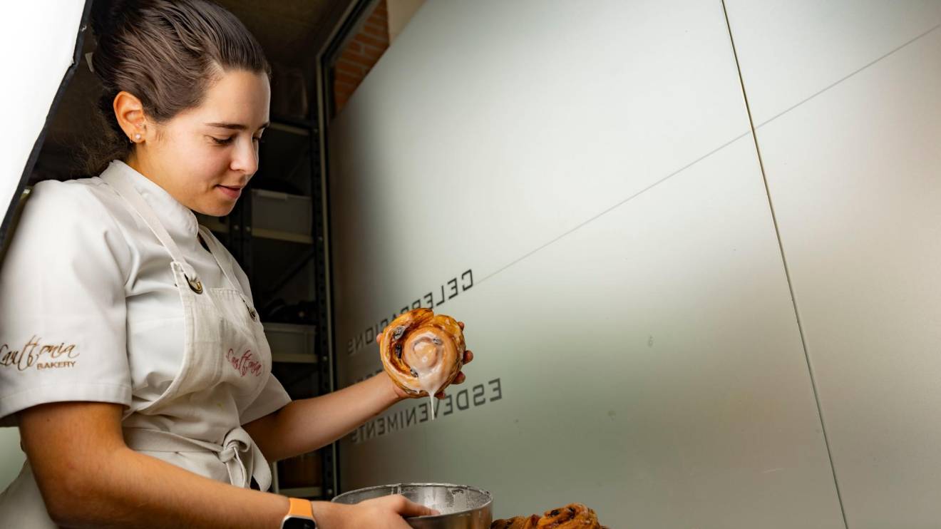 Elena Martínez baña los cinnamon rolls con un glaseado de azúcar. FOTO: ÀNGEL ULLATE