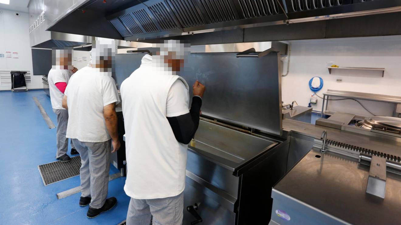 Tres internos en una foto de archivo trabajando en las cocinas del Centro Penitenciario de Mas d’Enric. Foto: DT