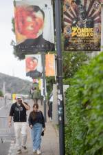 Carteles y viandantes en una de las calles que dan al Auditorio. foto efe