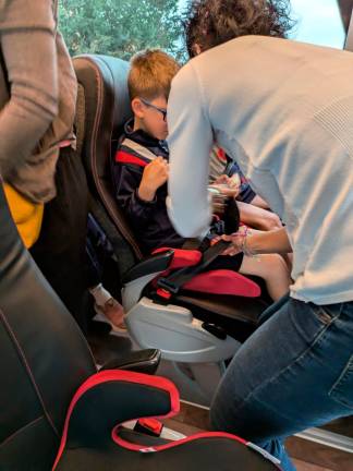 $!Un niño con alzador en el asiento este martes 15 de octubre, mientras lo abrochan. Foto: cedida