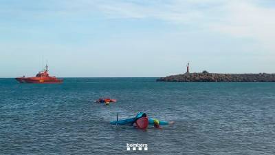 Los dos rescatadores remolcando la tabla y la vela y a la víctima hasta la orilla. Foto: Bombers