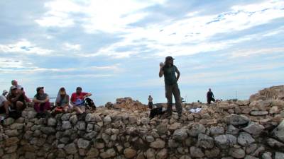 El director de la campanya d’excavacions a Sant Jaume-Mas d’en Serrà, David Garcia, mostra un betil (pedra sagrada) als assistents a la Jornada de portes obertes al jaciment d’Alcanar. Foto: J. J. BUJ