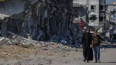 Imagen de dos personas paseando por una de las zonas destruidas en Gaza tras los Bombardeos. Foto: EFE