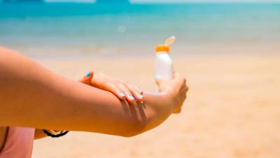 La exposición indiscriminada al sol es una de las causas de lupus. FOTO: GETTY IMAGESGirl applying sun lotion on her hands at the beach