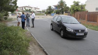 Un grupo de vecinos, en el tramo de la calle Oliveres que no tiene ni alumbrado público ni aceras. Foto: Pere Ferré