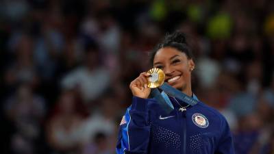 Simone Biles sonríe con fuerza en el podio con su medalla de oro. foto: efe