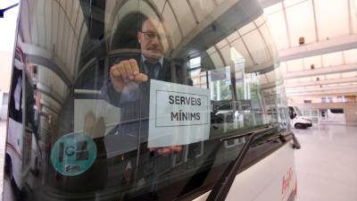 Un conductor posant el cartell de «Serveis Mínims» a l’estació d’autobusos de Tortosa. Foto: J. Revillas