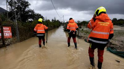 Bomberos inspeccionan una zona inundada. Foto: EFE