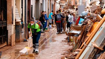 Varias personas ayudan a quitar barro en Aldaia. Foto: ACN