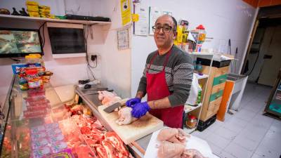 Ali Balkhir cortando la carne en su pequeño negocio de la calle Fortuny, la Carnicería Chaymae. FOTO: Marc Bosch