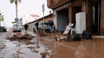 Varias personas limpian el lodo acumulado en sus viviendas a causa de las intensas lluvias por la fuerte dana que afecta especialmente el sur y el este de la península ibérica, este miércoles en Valencia. Foto: EFE