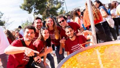 Estudiantes con la camiseta de Medecina delante de la paella popular de la Fiesta Mayor 2023. Foto: Cedida