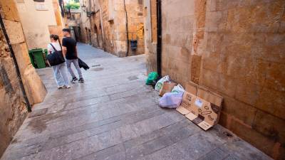 Una calle de la Part Alta con varias bolsas de basura y cartones en el suelo. Foto: Marc Bosch