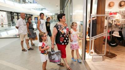 Martín y su familia mirando el escaparate de una tienda de La Fira Centre Comercial. Foto: Alba Mariné