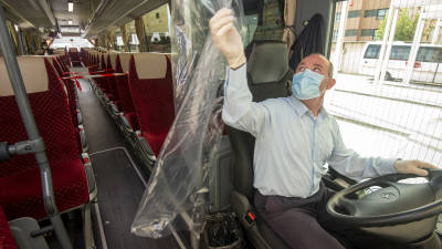 Un conductor de bus, con la protecci&oacute;n para minimizar riesgos. Foto: Joan Revillas