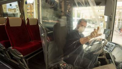 Un conductor, con guantes y mascarilla, protegido por un plástico para evitar el contacto con pasajeros. FOTO: JOAN REVILLAS