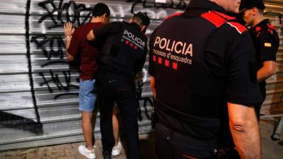 Imagen de varios agentes de los Mossos registrando a un hoven durante las fiestas de Santa Tecla, en Tarragona. Foto: ACN