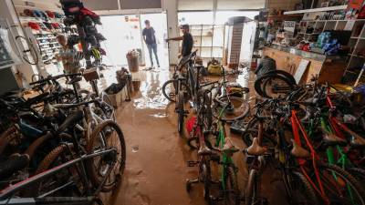 Varias personas evalúan los destrozos causados en el interior de su comercio en la localidad valenciana de Catarroja. Foto: EFE