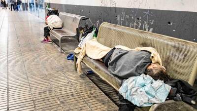 Personas durmiendo en los bancos de la estación de autobuses de Tarragona. Foto: Àngel Ullate