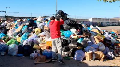 Un vecino de L’Arboç tirando la basura al área de emergencia. Foto: ACN