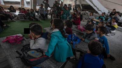 Niños palestinos se sientan en un aula entre los escombros de una escuela destruida en el campamento de Khan Younis, en el sur de la Franja de Gaza. Foto: EFE