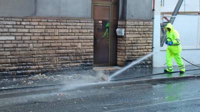 Un operario limpia la suciedad que ha atascado las alcantarillas de la calle Reial de Tarragona. Foto: ACN