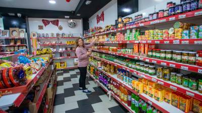 Silvia Gheorghe, en su tienda, mostrando la variedad de productos típicos de Rumanía. FOTO: Marc Bosch