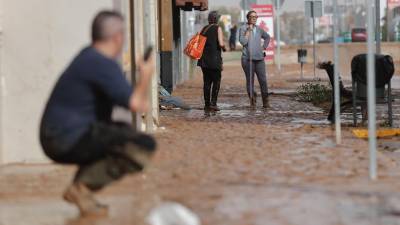 Varias personas limpian el lodo acumulado a causa de las intensas lluvias por la fuerte dana que afecta especialmente el sur y el este de la península ibérica, este miércoles en Valencia. Foto: EFE