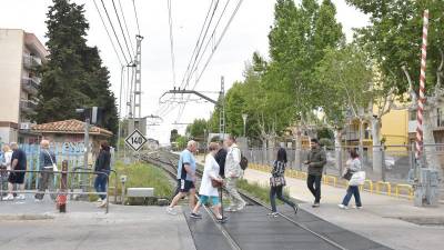 Un grupo de vecinos cruzando el paso a nivel que hay en Salou. Foto: Alfredo González