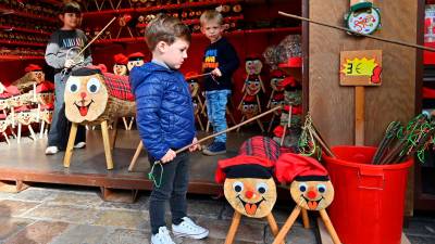 Al darrere, l’Ona i el Julià i, al davant, l’Èric, fent cagar uns tions del Mercat de Nadal de Reus. FOTO: Alfredo González