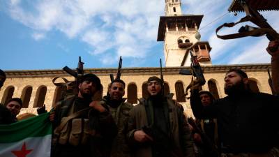 Un grupo de soldados rebeldes celebran en Damasco su victoria y la huida de Bashar Al Asad. foto: 06 Firma Foto