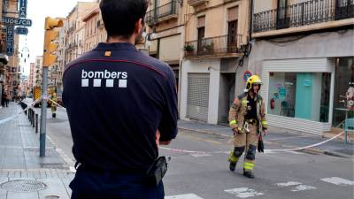 Dos agentes de los Bombers trabajando en un edificio con riesgo de derrumbamiento en la calle Unió de Tarragona. Foto: ACN