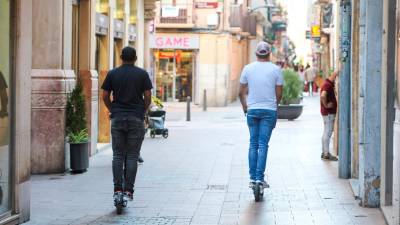 Dos patinetes eléctricos circulando por la calle de Jesús, que es peatonal. FOTO: Alba Mariné