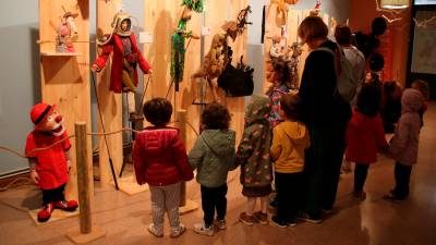 Diversos alumnes d’una escola de Valls mirant l’exposició de titelles del Teatre Principal abans d’entrar a veure l’espectacle ‘Es ven germà petit’ del festival Guant. Foto: ACN