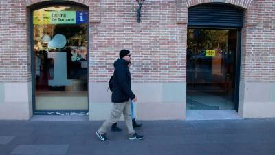 Dos personas pasan frente a la nueva oficina de Turisme de Catalunya. Foto: ACN