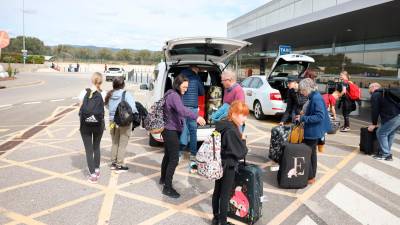 Turistas procedentes de Birmingham a través de Jet2, cargando ayer sus maletas en un taxi en el Aeropuerto de Reus. FOTO: Alba Mariné