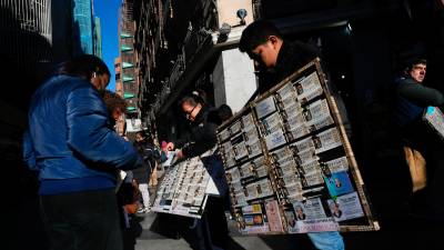 Unas personas venden lotería de Navidad en la calle Preciados en Madrid este sábado. Foto: EFE