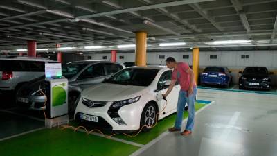 Nicolàs conectando su coche híbrido enchufable en los cargadores del parking de la Llibertat de Reus. FOTO: Fabián Acidres