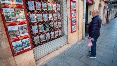 Un ciudadano mira los precios de viviendas en una inmobiliaria de Tarragona. foto: marc bosch