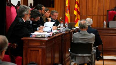 Los empresarios José Miguel Yubero y Juan Carretero de espaldas, acompañados de sus abogados al inicio del juicio que ha comenzado después de 31 años en la Audiencia de Tarragona. Foto: ACN