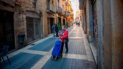 Una mujer empuja un carro por el Carrer Major. La proporción de vecinos mayores ha bajado casi a la mitad en veinte años. Foto: Marc Bosch