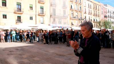 Una mujer aplaude al final del acto de apoyo a los afectados por la DANA en la Comunidad Valenciana, celebrado en la plaza de la Font de Tarragona. Foto: ACN