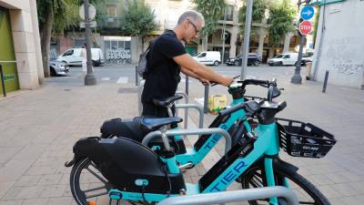 Un usuario cogiendo una bicicleta eléctrica. Foto: Pere Ferré