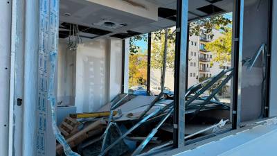 En el cruce de las calles Josep Maria Vives i Salas y Francolí ha caído parte de la pared de unos bajos comerciales en obras. Las ventanas estaban tapadas con pladur y una estructura metálica. Fotos: Celia Alonso