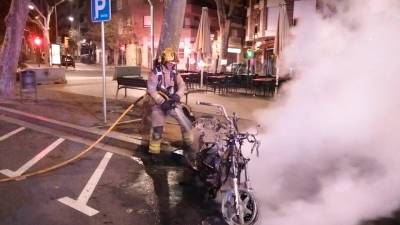 Un bombero apagando el fuego esta madrugada de sábado en Reus. FOTO: Bombers