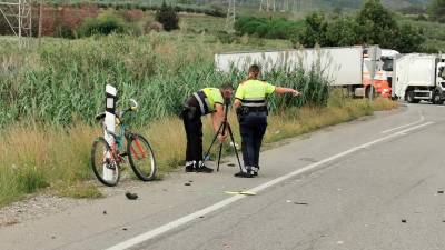 Dos mossos d’esquadra junto a la bicicleta del ciclista fallecido en Botarell. Foto: Àngel Juanpere