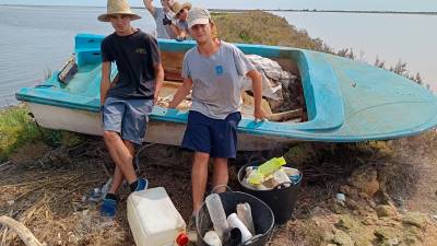 Joves fent la neteja en una de les embarcacions abandonades que es retiraran. Foto: Fundació Salines Marines