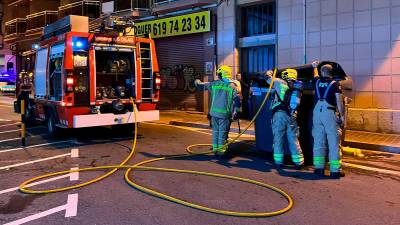 Una dotación de Bombers de la Generalitat remoja un contenedor de la calle Pròsper de Bofarull. Foto: Alfredo González