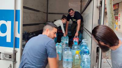 Voluntarios cargando los productos donados. Foto: STR