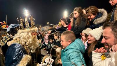 El rey Melchor saluda a los niños después de desembarcar en el puerto de Cambrils, antes de recorrer las calles de la ciudad, hasta el Ayuntamiento. foto: MCG